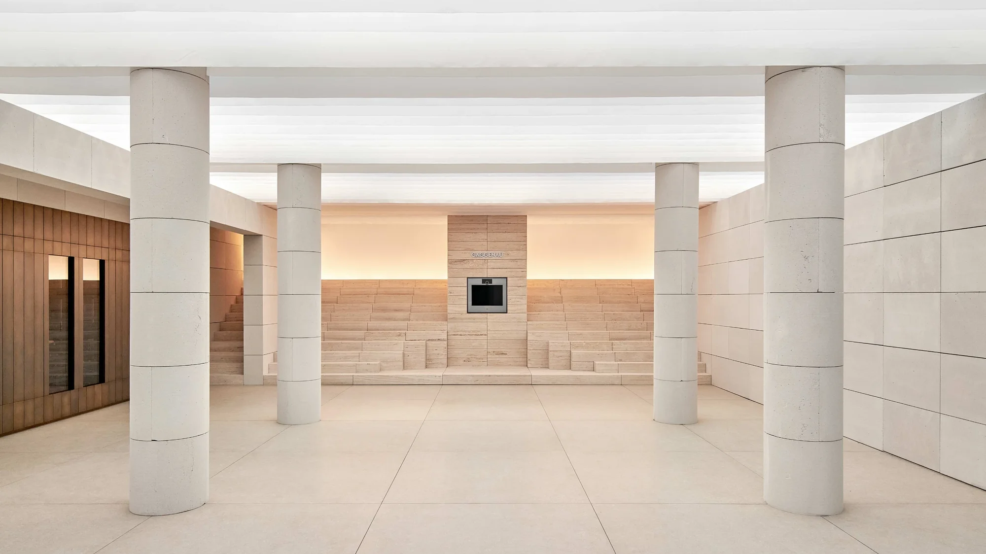 Der Backofen der Gaggenau Serie Expressive wird von einer zentralen Treppe aus Travertin wirkungsvoll in Szene gesetzt.